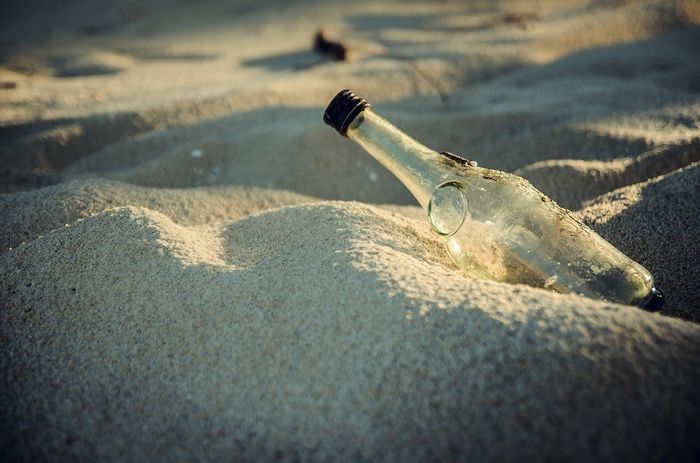 Glassflaske i sand