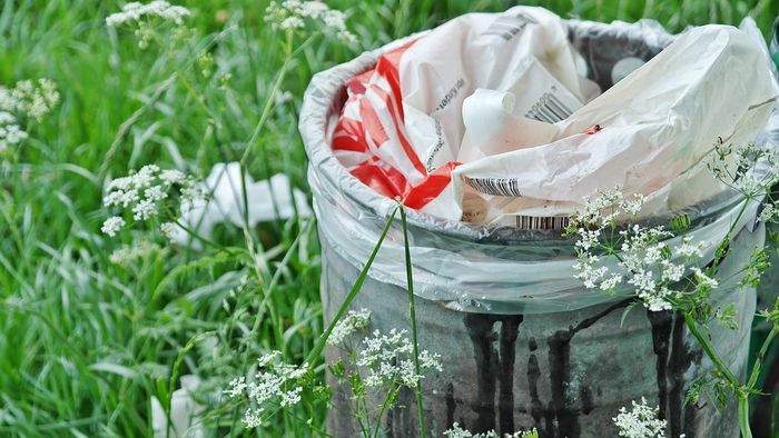 Plast i søppelbøtte i natur