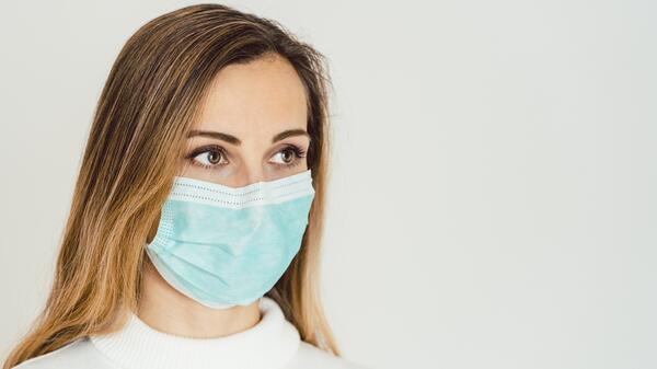 Anxious woman with face mask worried about the Covid-19 outbreak