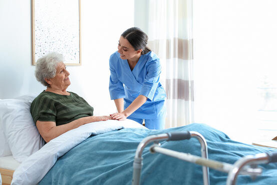 En helsefagarbeider prater med en pasient