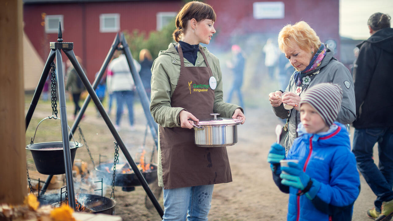 Foto av folk som lager mat på bål