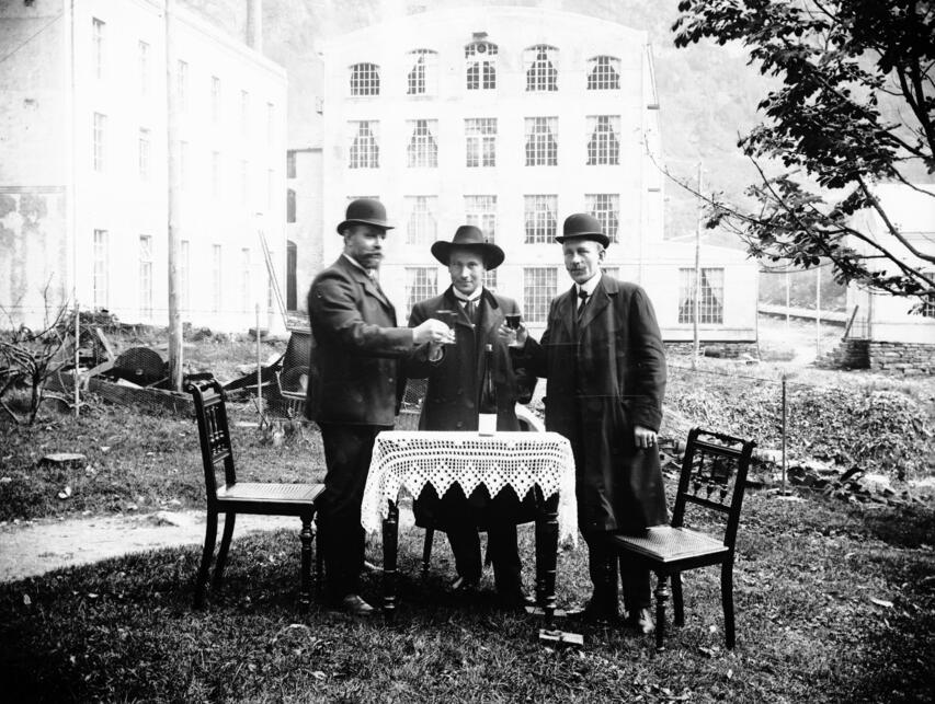 Fotograf og spinnerimeister Wilhelm Salberg (til venstre) og to ukjende menn skålar framfor bomullsfabrikken i Dale, kring 1910. Foto: Wilhelm Salberg