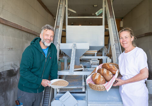 Foto av Trude Bergundhaugen og Arne Bøhmer med Ringsaker brød laget med lokalprodusert mel.
