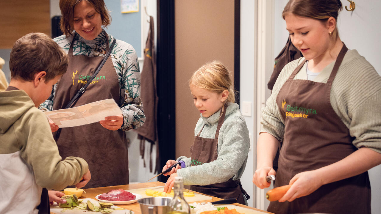 Foto av familie som lager mat på familiematkurs