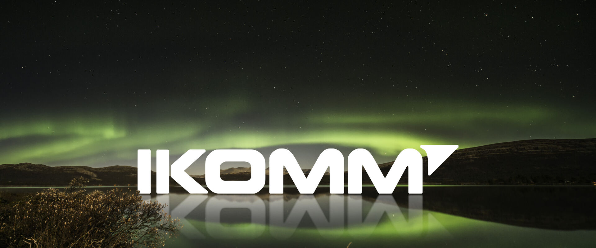 Logoen til Ikomm i utsiktsbilde med nordlys