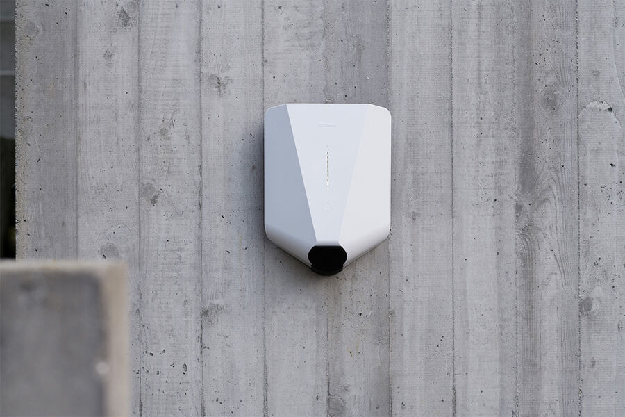 White Easee charger mounted on concrete wall