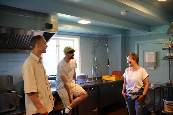På bildet (fra venstre): Harald Kindseth og Martin Hauge er med i gjengen som drifter Magerøya. Her viser de frem det nye kjøkkenet til assisterende kommunedirektør Anita Ørsal Oterholm. (Foto: Reidar Klungervik)