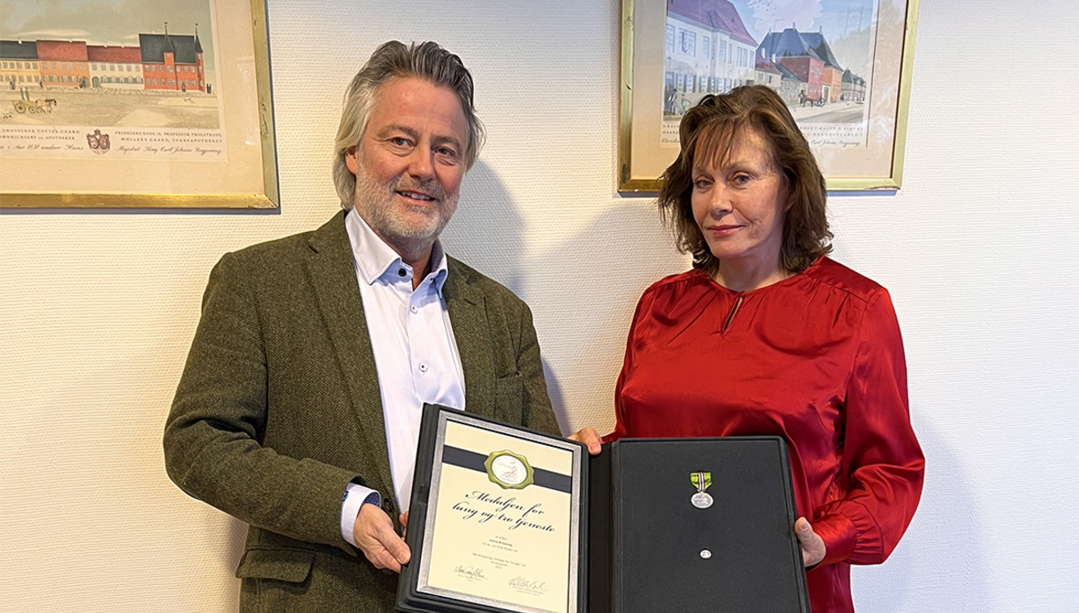 Anita Kopseng ble nylig tildelt Medaljen for lang og tro tjeneste hos NEK Kabel AS. Her mottar hun prisen av daglig leder i NEK Kabel, Alexander Dillingøen.