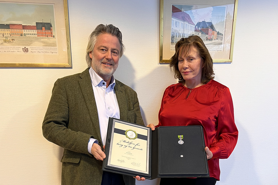 Anita Kopseng ble nylig tildelt Medaljen for lang og tro tjeneste hos NEK Kabel AS. Her mottar hun prisen av daglig leder i NEK Kabel, Alexander Dillingøen.
