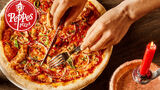 Bildet viser et par hender som skjærer opp en pizza