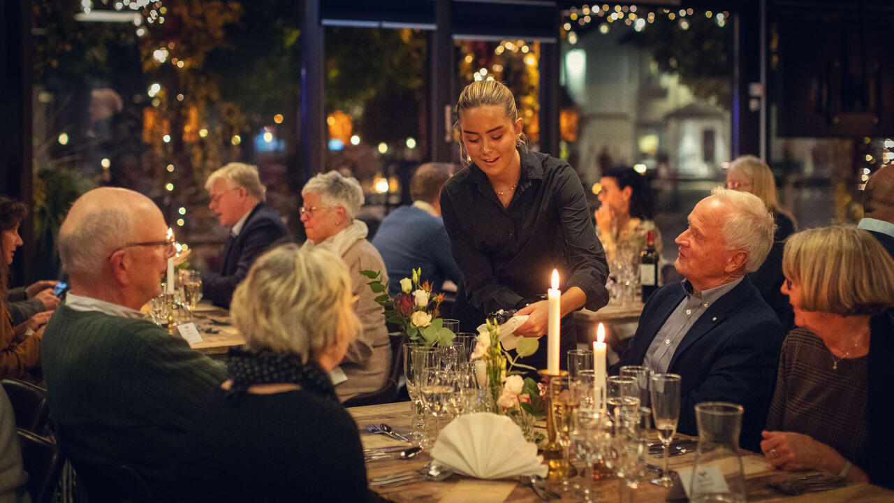 Bilde av voksne mennesker som sitter rundt et bord