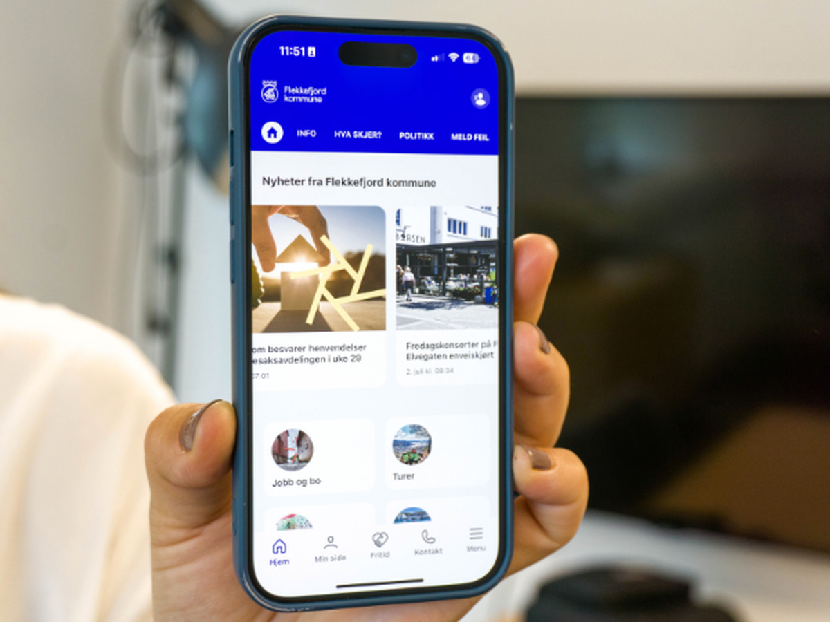 En hånd som holder en mobilskjerm med appen på