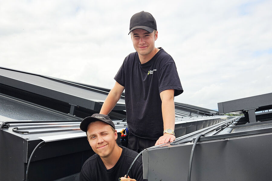 – Vi brukte til sammen tre dager på montasjearbeidet. Det var en enkel og grei montasje der profilene og gradrennebrettetene, ble limt fast på taket og takrenna, sier montør Terje Slettebakken (foran) og lærling Mathias Heggelund hos Gardermoen Elektro.