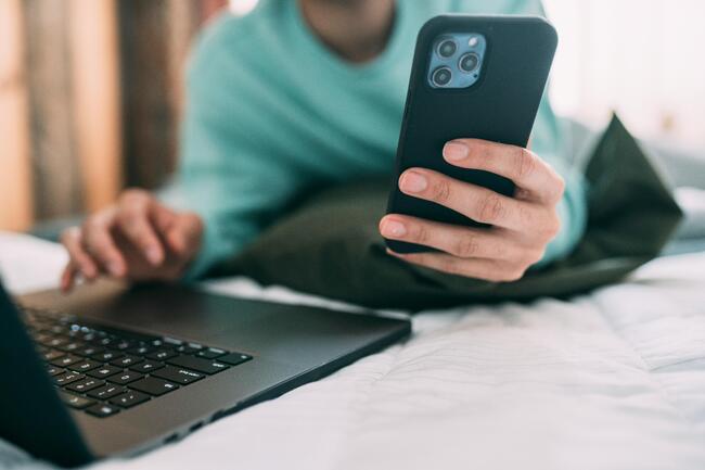 Person med mobil- og laptop Foto: Hoffman, Pexels.com