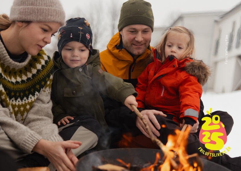 Bilde av familie som sitter rundt et bål