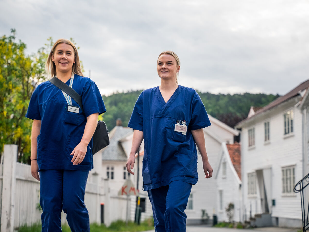 To jenter i sykepleier uniform i gatene i Flekkefjord.