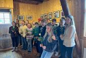 Bilde av elevene med hver sin rose. De står foran fotografiene.
