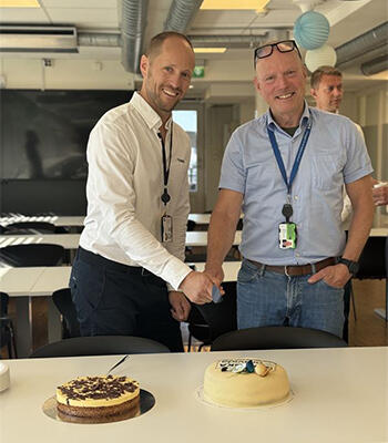 GODT HUMØR: Prosjektleder Eivind Søgaard i Bravida og prosjektsjef Stein Johnsen i Skanska skjærer første biten av marsipankaka.