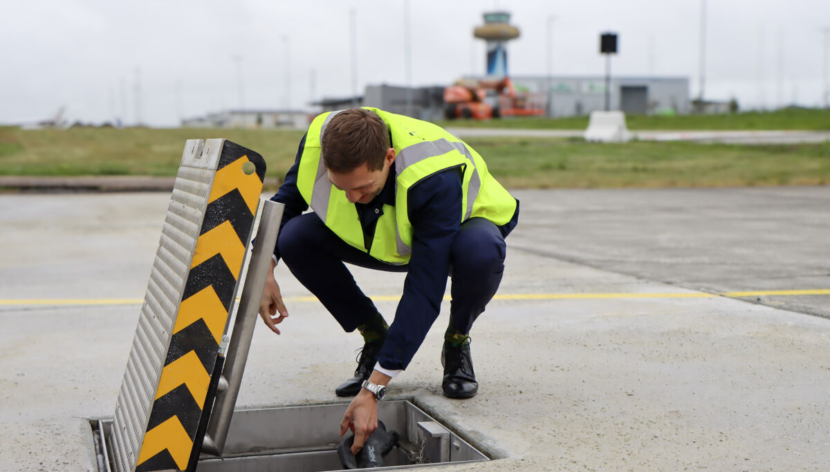 Klima- og miljøminister Andreas Bjelland Eriksen ved den nye elflyladeren på Stavanger lufthavn. Foto: Camilla Walla/Avinor