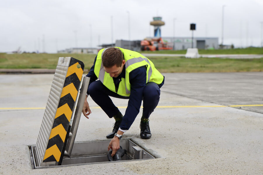 Klima- og miljøminister Andreas Bjelland Eriksen ved den nye elflyladeren på Stavanger lufthavn. Foto: Camilla Walla/Avinor