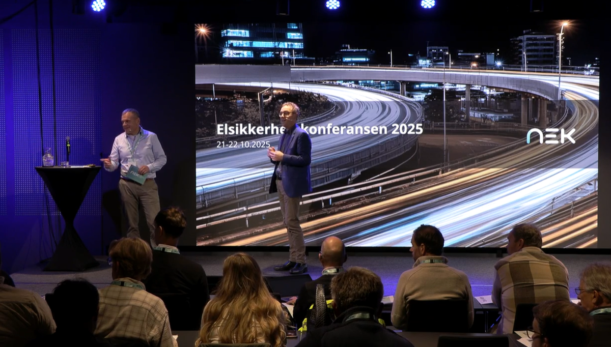 Fagansvarlig lavspenning Erik Arnholdt Johannessen (til venstre på scenen)  i NEK har bakgrunn fra ITB-koordinering hos totalentreprenør og byggherre og har sett svakheter i mange byggeprosjekter. På NEKs konferanse i oktober holdt han foredraget «Er smart så smart – eller en fallitterklæring?».