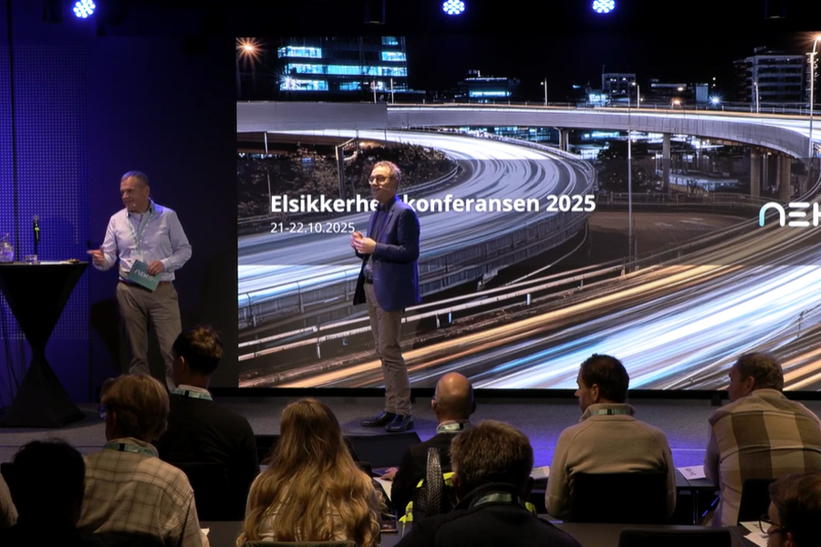 Fagansvarlig lavspenning Erik Arnholdt Johannessen (til venstre på scenen)  i NEK har bakgrunn fra ITB-koordinering hos totalentreprenør og byggherre og har sett svakheter i mange byggeprosjekter. På NEKs konferanse i oktober holdt han foredraget «Er smart så smart – eller en fallitterklæring?».