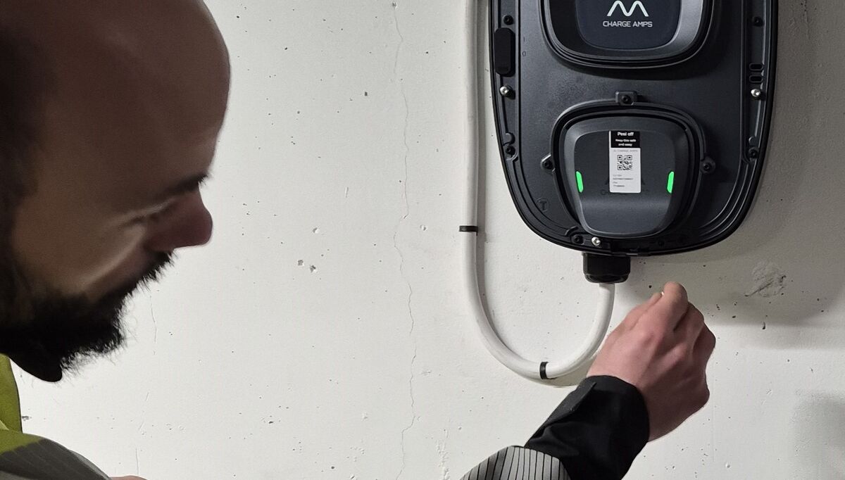 Montør installerer elbillader i parkeringshus. Foto: Bravida