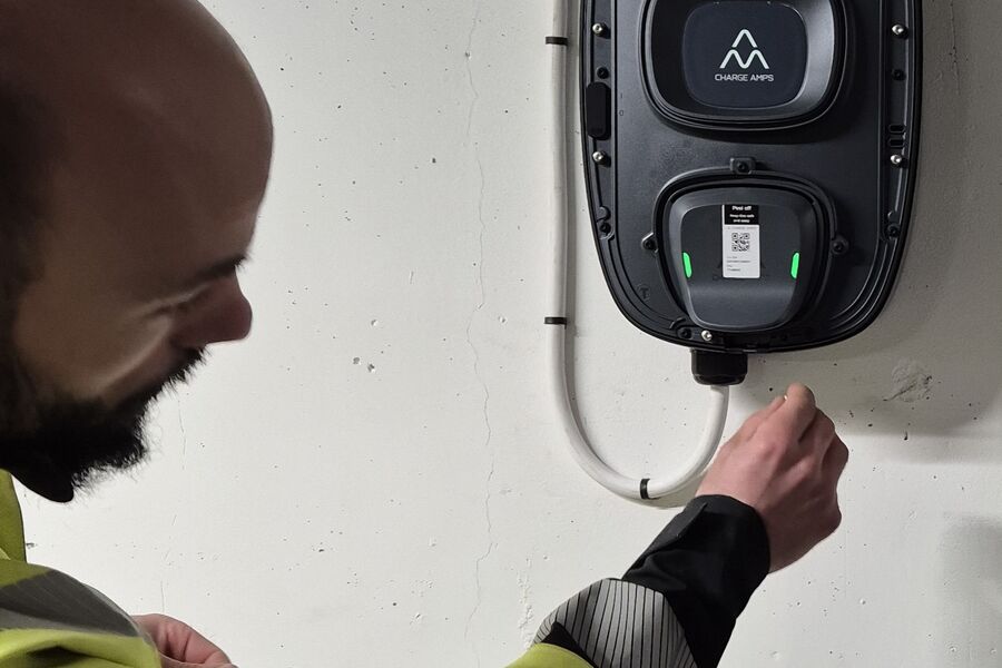 Montør installerer elbillader i parkeringshus. Foto: Bravida