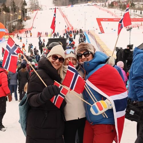 Blide publikummere med flagg heier på alpinistene i Hafjell