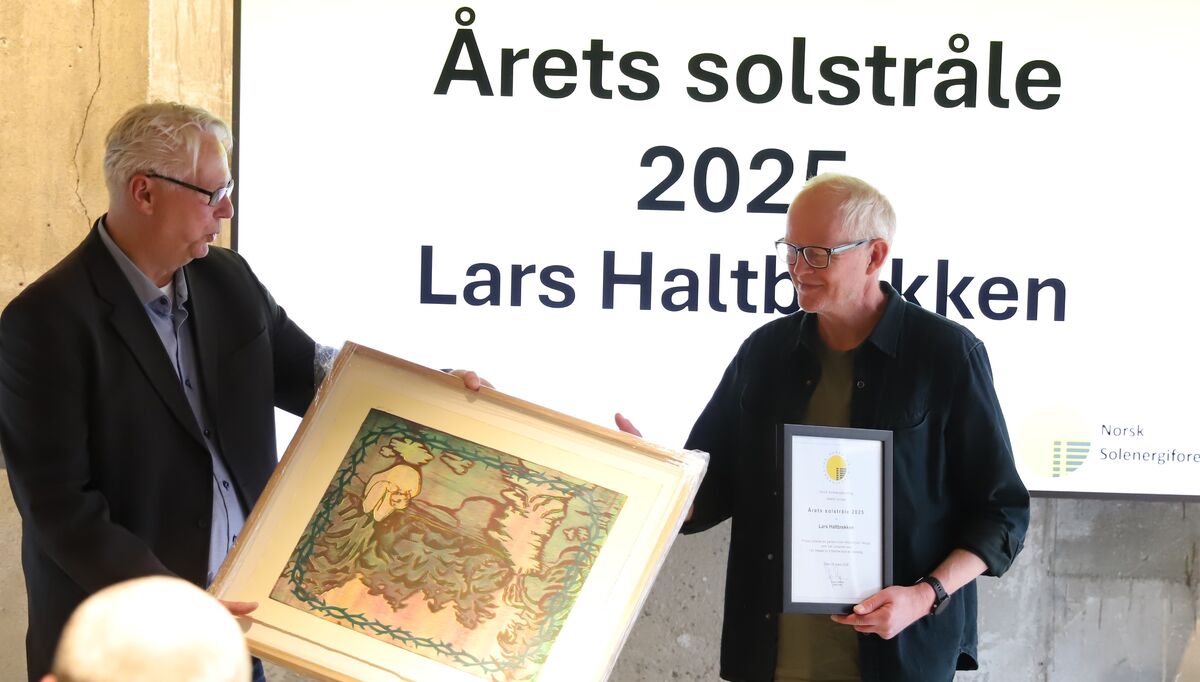 Lars Haltbrekken får overrakt diplom og gave for sin innsats for solenergi.